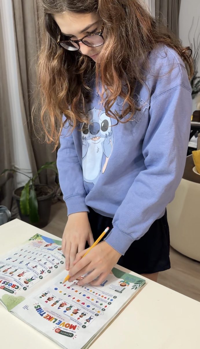A girl works on a Neuro Games page with a pencil