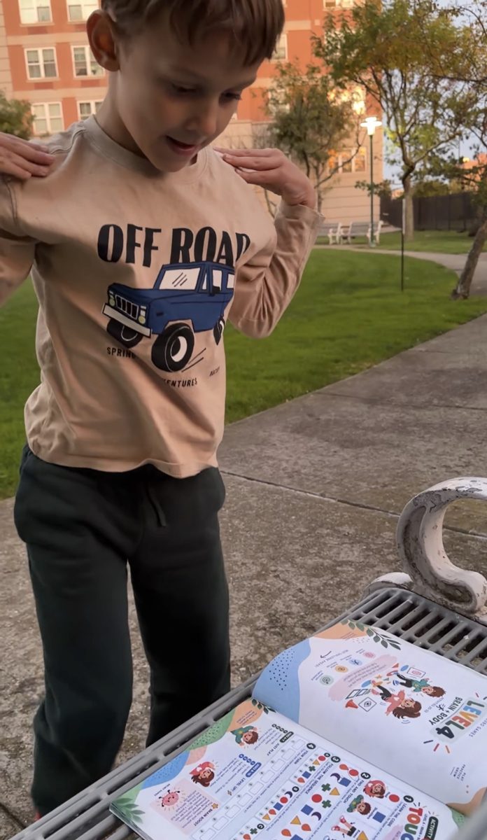 A boy does a movement from the book outdoors
